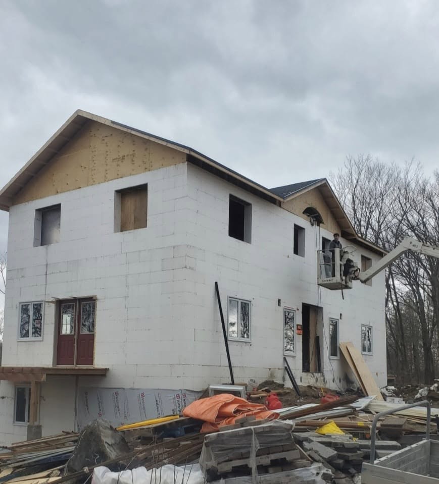 Cottage addition under construction with new window and door openings