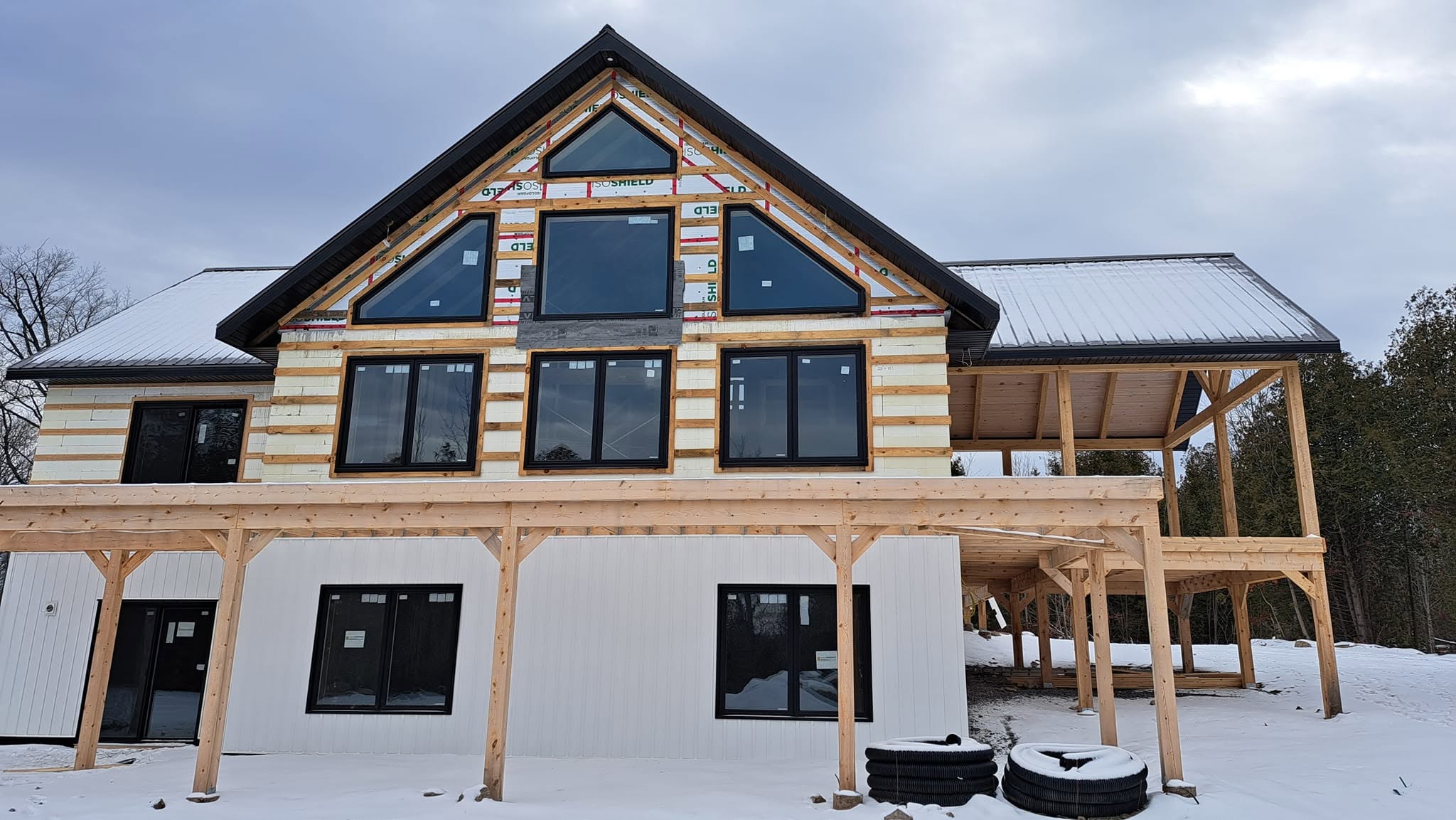 Modern cottage project photographed during exterior construction with black windows in place