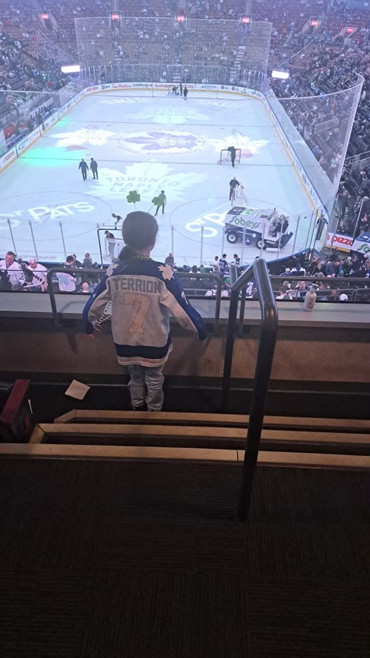 Child wearing a Terrion number 7 hockey jersey at a hockey game